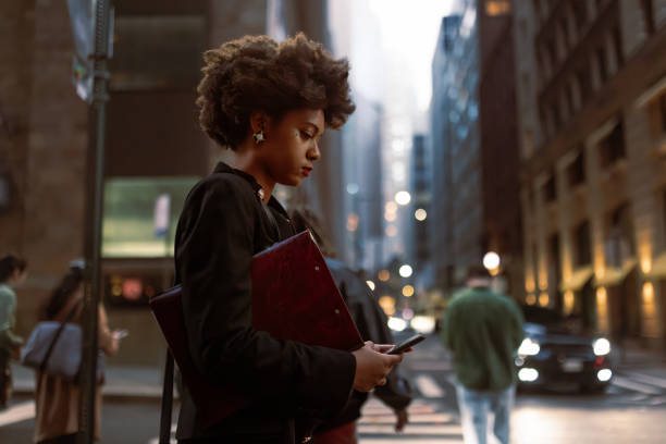 istock Efficient and Focused: Busy Black Professional Awaits Taxi, Managing Documents and Email 1492315479
