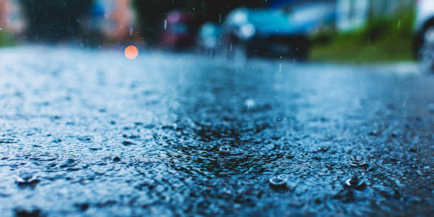 istock Raindrops on road. Wet asphalt. Rain. Weather. Puddle. Car 1492315856