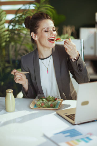istock smiling modern woman worker in modern green office eating salad 1492321919