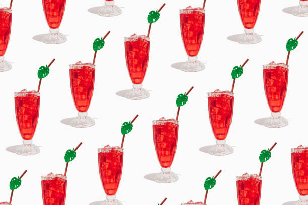 白い背景に冷たいさわやかな赤いカクテルと角氷とストローのグラス。 夏の飲み物、パーティーシーン。トレンディなミニマリストの休暇の構成。 - drink umbrella cocktail glass isolated ストックフォトと画像