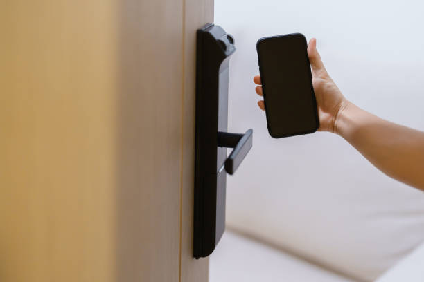 istock Hand using smartphone for open digital door lock at home or apartment. NFC Technology, Fingerprint scan, keycard, PIN number, smartphone, electrical and contactless lifestyle concepts 1492326921