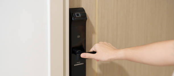 istock Hand using smart digital door lock while open or close the door at home or apartment. NFC Technology, Fingerprint scan, keycard, PIN number, smartphone, electrical and contactless lifestyle concepts 1492326976