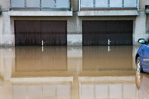 Car in a flood and water to the garage door handle.