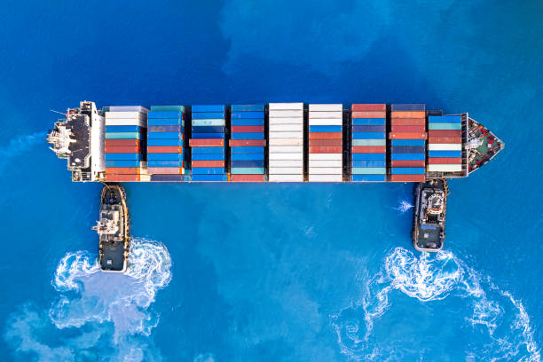 istock Tugboats assisting container cargo ship to harbor. 1492331500