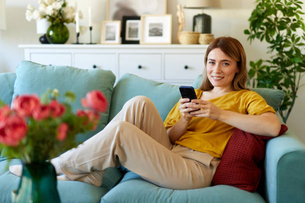 istock Woman using smartphone while drinking coffee at her home in the morning 1492333949