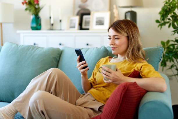istock Woman using smartphone while drinking coffee at her home in the morning 1492333987
