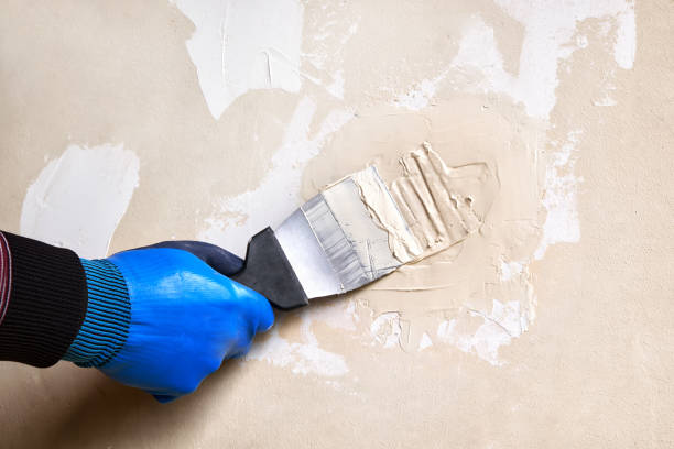istock A man is plastering a damaged wall in a room with a hand trowel. 1492334662