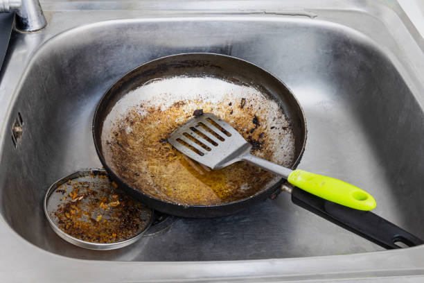 This is a candid photograph of dirty dishes in the kitchen sink at home.