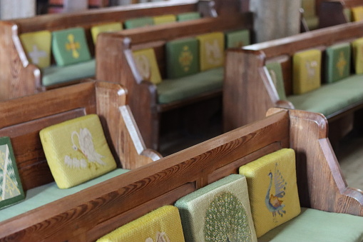 Wooden church pews with kneeling cushions