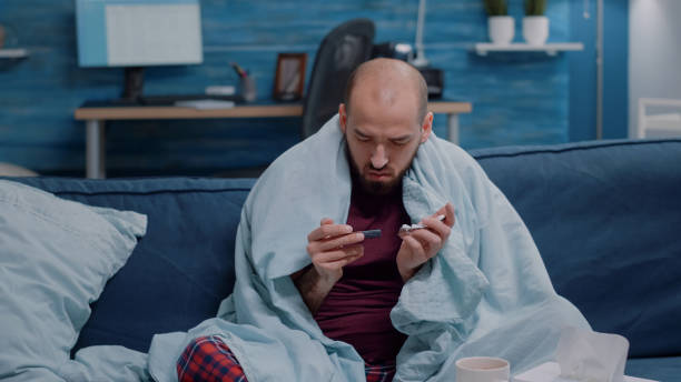 istock Unwell man holding tablets with capsules in hand 1492341639