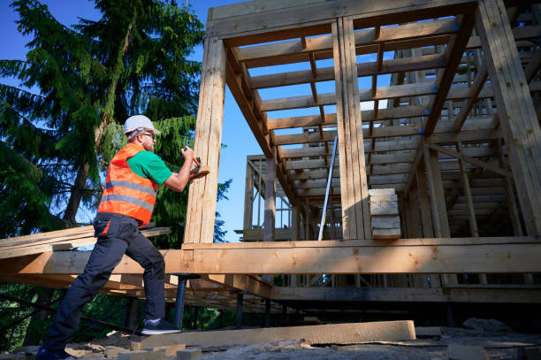 istock Carpenter hammering nail while constructing wooden frame two-story house near the forest. 1492343343
