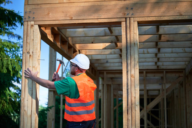 istock Carpenter hammering nail while constructing wooden frame two-story house. 1492343477