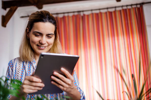 istock Lovely housewife using digital tablet at home 1492343625