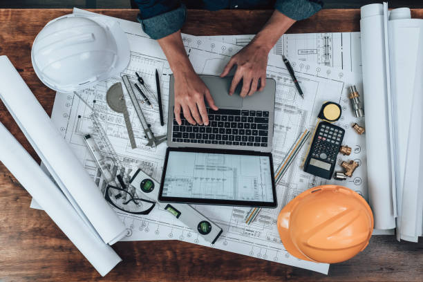istock Engineering working with drawings inspection on laptop  in the office and Calculator, triangle ruler, safety glasses, compass, vernier caliper on Blueprint. Engineer, Architect, Industry and factory concept. 1492344102