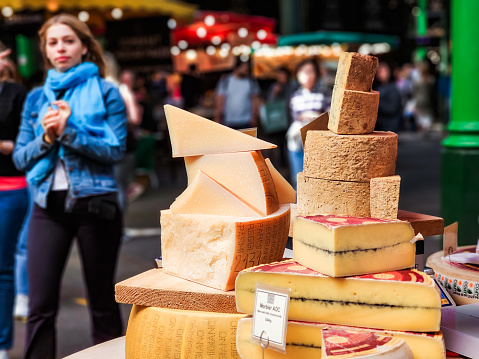London, UK - 16 May, 2023: large selection of cheese on display and for sale at a market stall in Borough Market, London, UK.