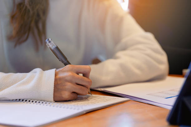 istock Close-up of university students writing on notebook with tablet on the table 1492346763