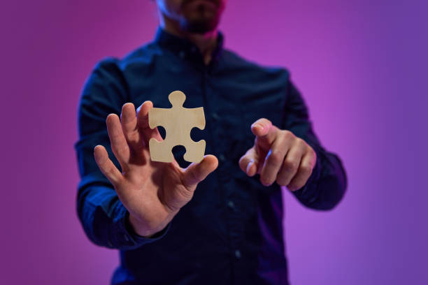 istock Businessman holding puzzle symbolizing teamwork, partnership, business cooperation and successful strategy 1492354433