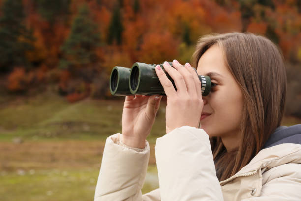 istock Woman looking through binoculars in beautiful mountains, closeup. Space for text 1492354559