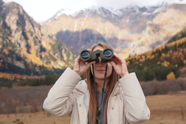 istock Woman looking through binoculars in beautiful mountains 1492354560