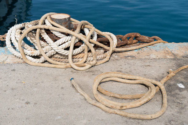 Anchored in Tradition: Exploring the Rustic Beauty of a Fishing Port's Mooring Bollards Anchored in Tradition: Exploring the Rustic Beauty of a Fishing Port's Mooring Bollards mooring line stock pictures, royalty-free photos & images