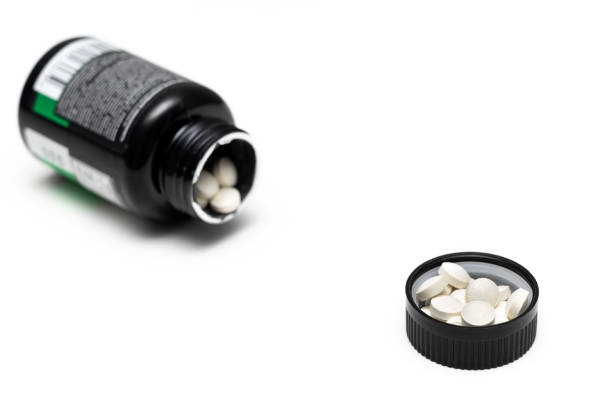 istock pills lie in a bottle cap on a white background 1492363816