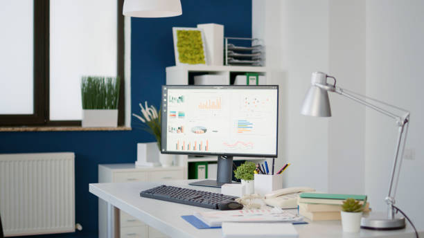 istock Empty desk with computer monitor showing financial statistics charts 1492364983