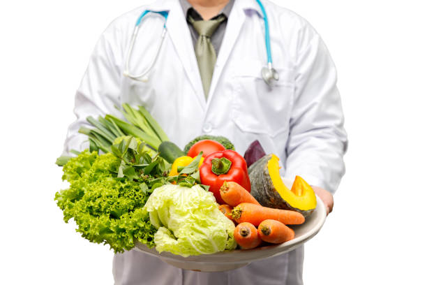 istock Doctor holding basket assort fresh vegetables isolated on white background. 1492366013