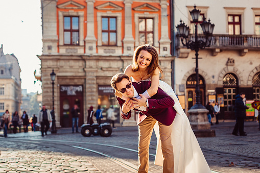 Happy couple against the background of the pavement and historic buildings