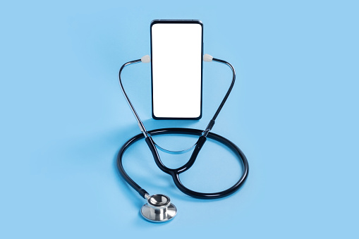 Online doctor. Mobile phone mockup for medical app. Smartphone white screen mockup and stethoscope for health application. App health phone mockup. Banner with copy space