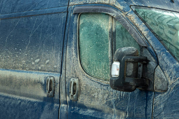 istock a cargo van covered in a layer of dirt, the front door with a window and a mirror with a turn signal splattered mud, close up detail of vehicle. 1492374696