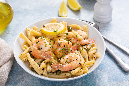 Shrimp piccata pasta with lemon and capers in a white bowl