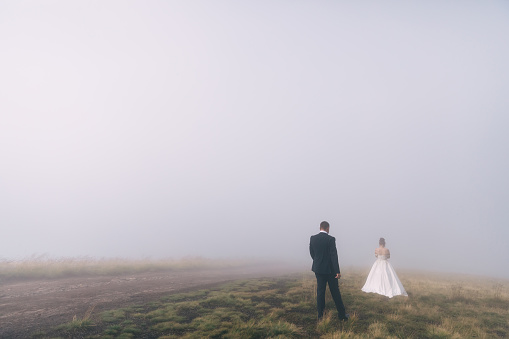 bride and groom on the background of fairy fog in the forest. Rustic wedding concept.
