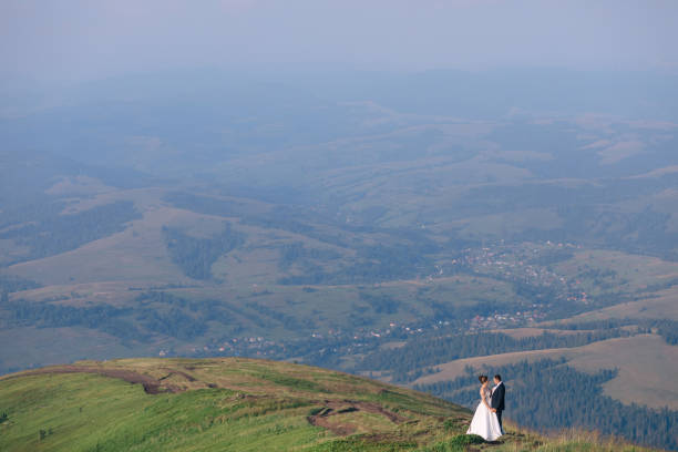 istock Young couple standing against the backdrop of mountains, fields 1492376561