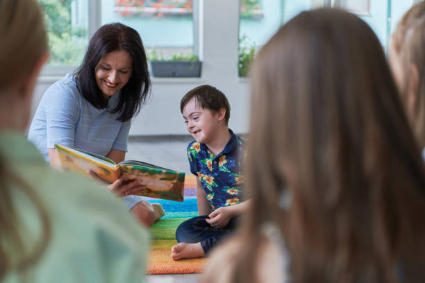 istock Reading time in an elementary school or kindergarten, a teacher reading a book to children in an elementary school or kindergarten. The concept of pre-school education. Selective focus 1492376596