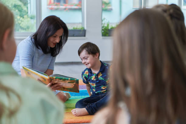 istock Reading time in an elementary school or kindergarten, a teacher reading a book to children in an elementary school or kindergarten. The concept of pre-school education. Selective focus 1492376721