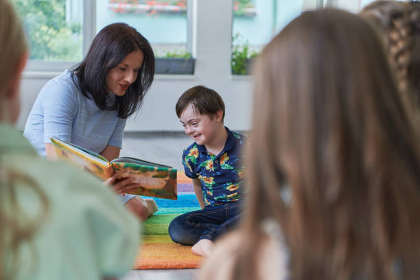 istock Reading time in an elementary school or kindergarten, a teacher reading a book to children in an elementary school or kindergarten. The concept of pre-school education. Selective focus 1492376855