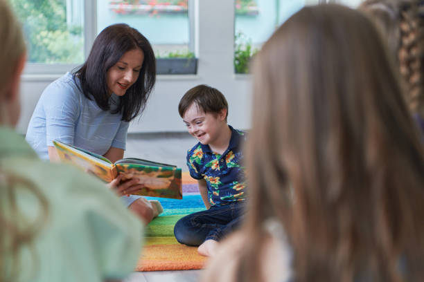 istock Reading time in an elementary school or kindergarten, a teacher reading a book to children in an elementary school or kindergarten. The concept of pre-school education. Selective focus 1492376971