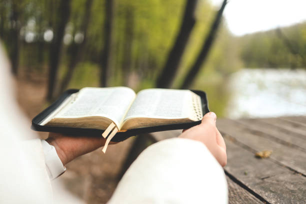 istock Open Bible in hands, morning reading in nature 1492378400