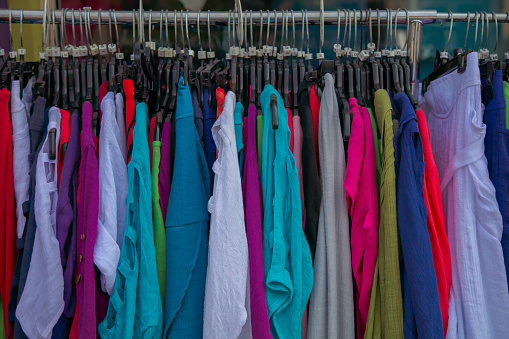 women's clothes on a shirt rack in a thrift shop fashion boutique