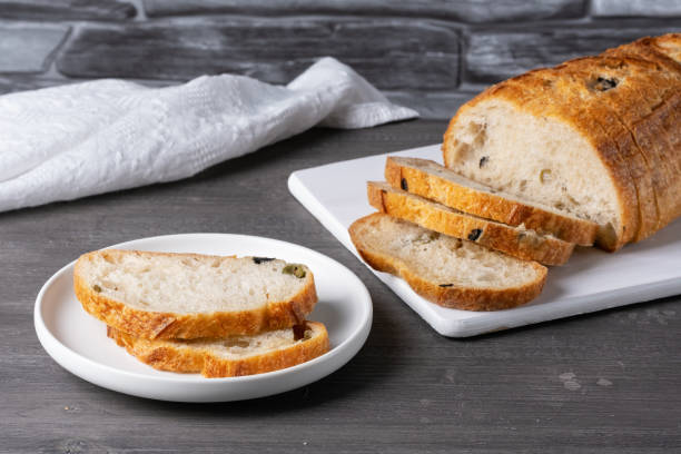 istock Bread with olives on a white cutting board on a gray table 1492383263