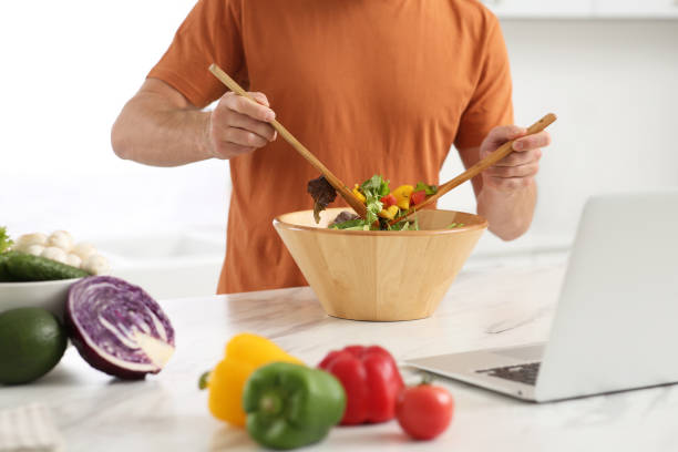 istock Man making dinner while watching online cooking course via laptop in kitchen, closeup 1492387676