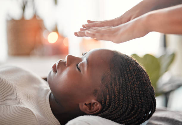 リラックスして、レイキと黒人女性がスピリチュアルチャクラ療法と代替医療のためにスパに横たわっています。癒し、バランスと禅、伝統的なマッサージで平和な考え方と健康な心を持つ� - reiki alternative therapy massaging women ストックフォトと画像