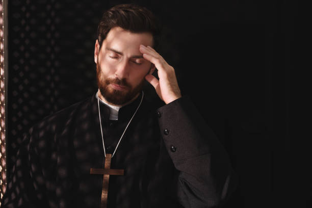 istock Catholic priest wearing cassock in confessional booth 1492387785