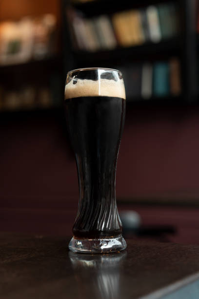 still life of glass of stout beer on pub table - rustic beer brewery indoors imagens e fotografias de stock