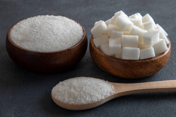 istock Cube sugar and granulated sugar on black background 1492390584