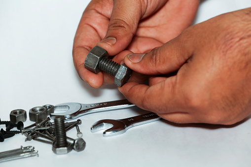 Human hand picking wrench tool or nut bolt for repairing of the machine.