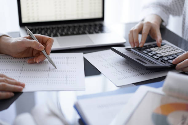 istock Woman accountant using a calculator and laptop computer while counting taxes for a client. Business audit concepts 1492395669