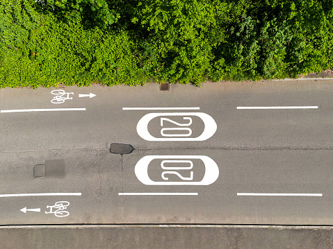 Aerial view of road markings for a 20 mph speed limit zone and cycle lanes. No people.