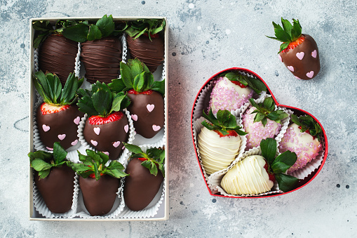 Gourmet chocolate covered strawberries on the light background. Delicious strawberries in a box for Valentine's Day.