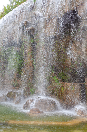 Waterfall in nature. Splashes of water running down stones. Summer day